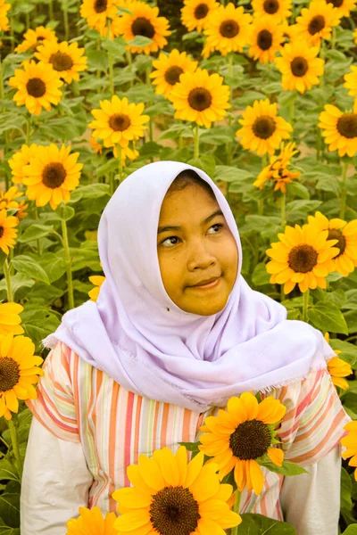 portrait of a young beautiful asian woman with yellow sunflower in her hands