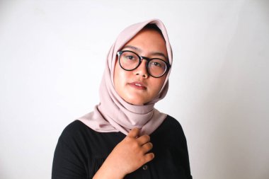 beautiful young woman in a hijab, looking through glasses and smiling