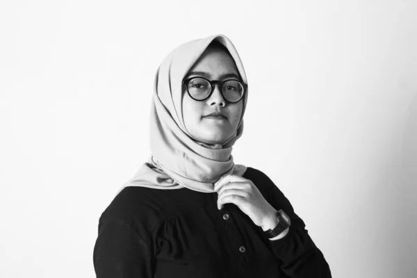 portrait of a young muslim woman in black clothes and glasses on white background