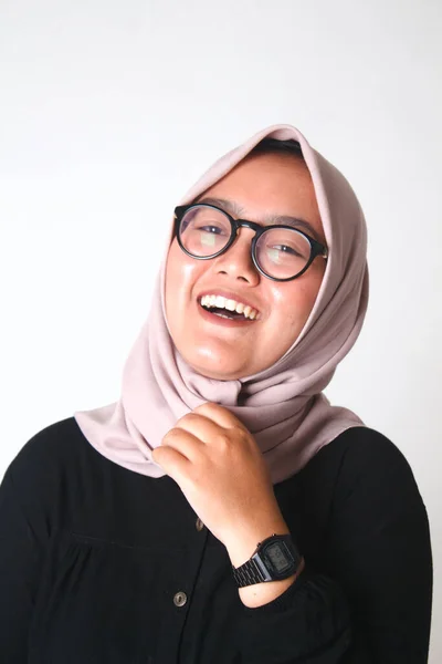 young beautiful woman wearing hijab and smiling, looking to camera with smile on face, touching chin and giggling