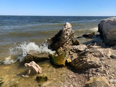 Deniz taşları kayalarda güçlü dalgaları kırıyor.