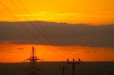 Gün batımında elektrik kuleleri ve kablolar