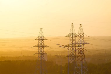 Gün batımında elektrik kuleleri ve kablolar