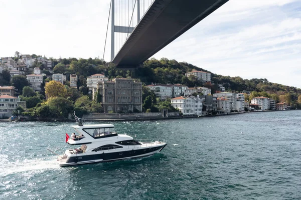 İstanbul 'da Boğaziçi, Rumeli Hisari Mahallesi ve FSM Köprüsü' nden geçen bir yatın görüntüsü. Güneşli bir yaz günü. Güzel seyahat sahnesi.