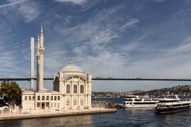 İstanbul 'daki tarihi Ortakoy camii ve köprüsü, Boğaz' daki gezi teknelerinin görüntüsü. Güneşli bir yaz günü..
