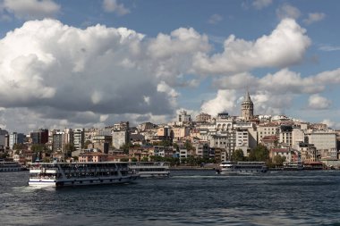 İstanbul 'daki Boğaz' ın Golden Horn bölgesindeki tur teknelerinin görüntüsü. Arka planda Galata kulesi ve Beyoğlu bölgesi var. Güneşli bir yaz günü..