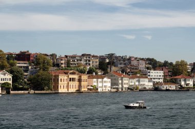 İstanbul 'un Asya yakasının Anadolu Hisari bölgesinde İstanbul Boğazı' nın tarihi ve geleneksel köşklerinin manzarası. Küçük balıkçı teknesi geçişleri. Güneşli bir yaz günü. Güzel seyahat sahnesi.