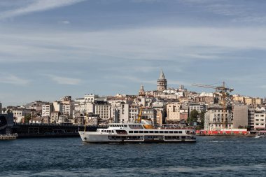 İstanbul 'daki Boğaz' ın Golden Horn bölgesinde geleneksel bir feribot manzarası. Galata kulesi ve Beyoğlu ilçesi manzaralı. Güneşli bir yaz günü..