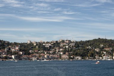 View of yachts and cruise tour boats on Bosphorus and Bebek neighborhood on European side of Istanbul. It is a sunny summer day. Beautiful travel scene.