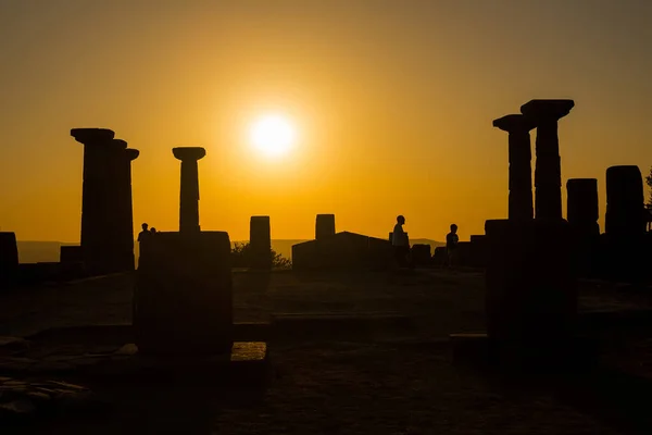 View of people and historical ruins at sunset captured in the temple of Athena at the ancient city of Assos located in Behramkale, Turkey