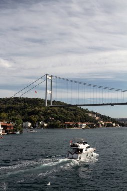 İstanbul 'un Asya yakasındaki Kanlica Mahallesi' nde boğazdan geçen yat manzarası. Arka planda FSM köprüsü var. Güneşli bir yaz günü. Güzel seyahat sahnesi.