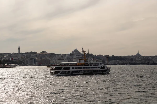 View of a traditional ferry boat on Golden Horn part of Bosphorus in Istanbul. Historical old town called Eminonu is in the background. Beautiful scene.