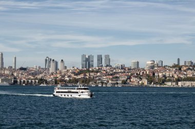 View of a cruise tour boat on Bosphorus and European side of Istanbul. It is a sunny summer day.