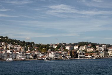 View of moored boats on Bosphorus and Arnavutkoy neighborhood on European side of Istanbul. It is a sunny summer day. Beautiful travel scene.