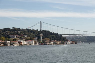 View of boats passing on Bosphorus, Kanlica neighborhood and FSM bridge in Istanbul. It is a sunny summer day. Beautiful travel scene.