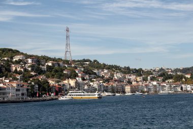 View of moored boats on Bosphorus and Arnavutkoy neighborhood on European side of Istanbul. It is a sunny summer day. Beautiful travel scene.