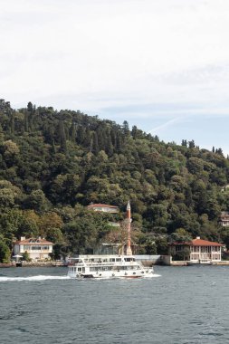 İstanbul 'un Asya yakasının Kandilli bölgesinde İstanbul Boğazı' ndaki gezi teknesi ve tarihi ve geleneksel malikanelerin manzarası. Güneşli bir yaz günü. Güzel sahne.