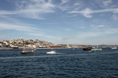 View of many tour boats on Bosphorus in Istanbul. European side is in the view. It is a sunny summer day.