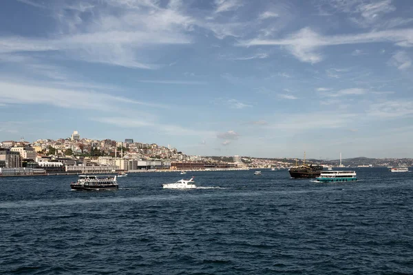 View of many tour boats on Bosphorus in Istanbul. European side is in the view. It is a sunny summer day.