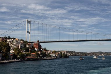 Boğaziçi 'ndeki tekneler, Avrupa yakasındaki Rumeli Hisari mahallesi ve İstanbul' daki FSM köprüsü manzaralı. Güneşli bir yaz günü. Güzel seyahat sahnesi.