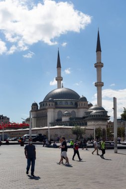 İstanbul 'da Taksim Meydanı' nda yürüyen ve yeni inşa edilen caminin manzarası. Güneşli bir yaz günü..