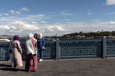 İstanbul 'daki Galata köprüsünde fotoğraf çeken kadınların görüntüsü.