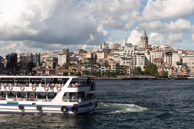 İstanbul 'daki Boğaz' ın Golden Horn bölgesindeki tur teknesinin görüntüsü. Arka planda Galata kulesi ve Beyoğlu bölgesi var. Güneşli bir yaz günü..