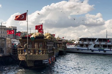View of traditional boats used for selling fish sandwich by Galata bridge in Istanbul. The image reflects the culture of the city. It is a sunny summer day.