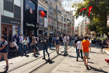 İstanbul 'da Istiklal Bulvarı' nda yürüyen insanların görüntüsü şehrin ana yaya bulvarı. 19. yüzyıl binaları, alışveriş zincirleri ve kafelerle dolu bir cadde. Güneşli bir yaz günü..