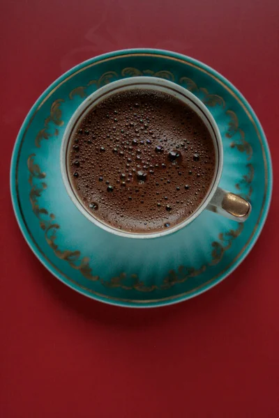 Black coffee in a green cup on a red background