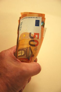 hand holding euro banknotes tightly