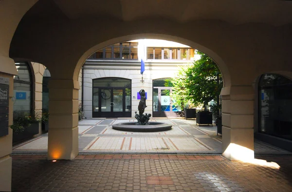 The arcade in the city with a fountain