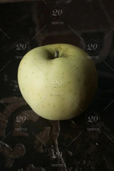 The white apple with a slight shadow on a dark background