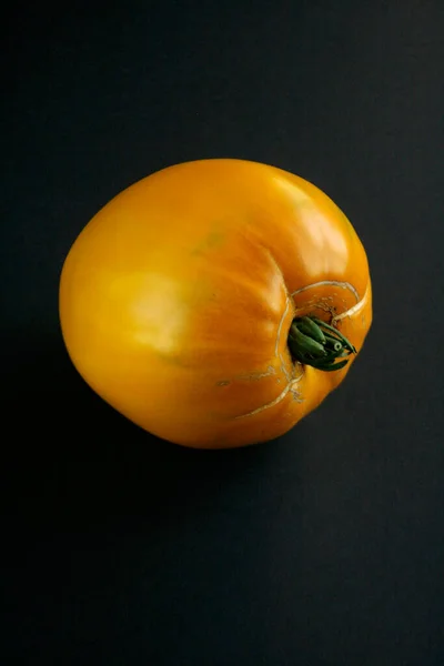 Fresh, yellow and juicy tomato on a dark background (2)