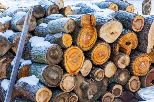 Stacked wood covered with snow. Background. A woodpile of dry fire woods in the winter. Stack of fire wood with snow. Winter fire wood provisions. Row of fire wood stock for winter. Winter..