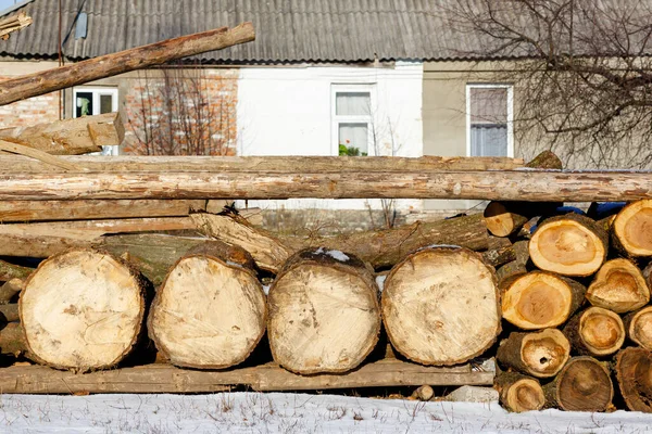 Stacked wood covered with snow. Background. A woodpile of dry fire woods in the winter. Stack of fire wood with snow. Winter fire wood provisions. Row of fire wood stock for winter. Winter..