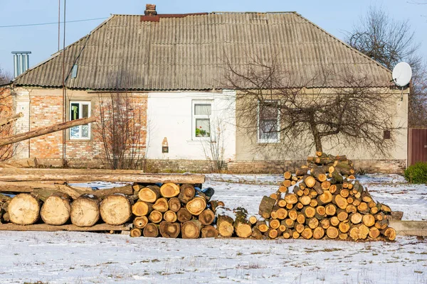 Stacked wood covered with snow. Background. A woodpile of dry fire woods in the winter. Stack of fire wood with snow. Winter fire wood provisions. Row of fire wood stock for winter. Winter..