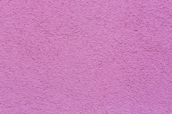 Sample texture pink plaster. The wall is finished with decorative cement stucco. An example of a decorative wall with pink cement. Pink concrete texture of walls for the background and wallpaper