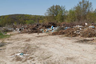 Çöp sahasının manzarası. Çöp yığını. Bir yığın plastik çöp, yiyecek atıkları ve diğer çöpler. Kirlilik konsepti. Bir çöp denizi, güzel bir kırsal alanı istila etmeye ve yok etmeye başlar..