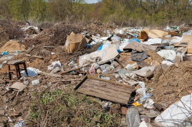 Çöp sahasının manzarası. Çöp yığını. Bir yığın plastik çöp, yiyecek atıkları ve diğer çöpler. Kirlilik konsepti. Bir çöp denizi, güzel bir kırsal alanı istila etmeye ve yok etmeye başlar..