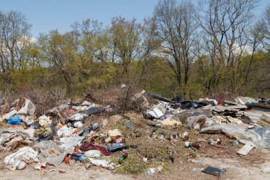 Çöp sahasının manzarası. Çöp yığını. Bir yığın plastik çöp, yiyecek atıkları ve diğer çöpler. Kirlilik konsepti. Bir çöp denizi, güzel bir kırsal alanı istila etmeye ve yok etmeye başlar..