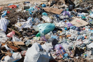 Çöp sahasının manzarası. Çöp yığını. Bir yığın plastik çöp, yiyecek atıkları ve diğer çöpler. Kirlilik konsepti. Bir çöp denizi, güzel bir kırsal alanı istila etmeye ve yok etmeye başlar..