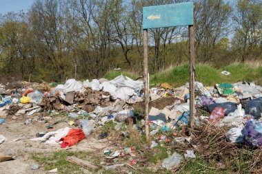 Çöp sahasının manzarası. Çöp yığını. Bir yığın plastik çöp, yiyecek atıkları ve diğer çöpler. Kirlilik konsepti. Bir çöp denizi, güzel bir kırsal alanı istila etmeye ve yok etmeye başlar..