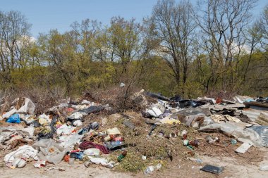 Çöp sahasının manzarası. Çöp yığını. Bir yığın plastik çöp, yiyecek atıkları ve diğer çöpler. Kirlilik konsepti. Bir çöp denizi, güzel bir kırsal alanı istila etmeye ve yok etmeye başlar..