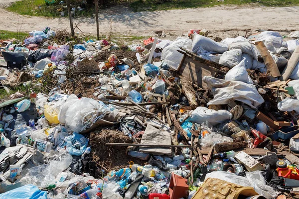 Çöp sahasının manzarası. Çöp yığını. Bir yığın plastik çöp, yiyecek atıkları ve diğer çöpler. Kirlilik konsepti. Bir çöp denizi, güzel bir kırsal alanı istila etmeye ve yok etmeye başlar..