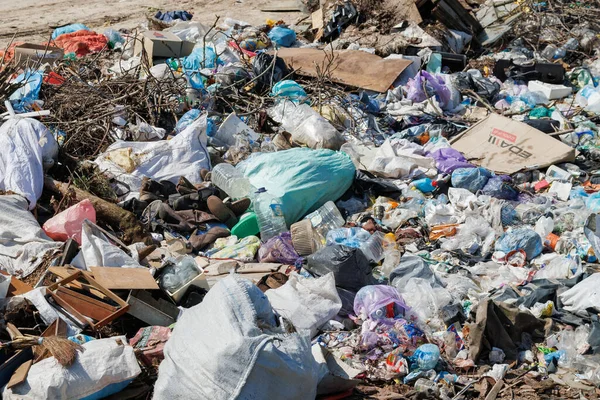Çöp sahasının manzarası. Çöp yığını. Bir yığın plastik çöp, yiyecek atıkları ve diğer çöpler. Kirlilik konsepti. Bir çöp denizi, güzel bir kırsal alanı istila etmeye ve yok etmeye başlar..