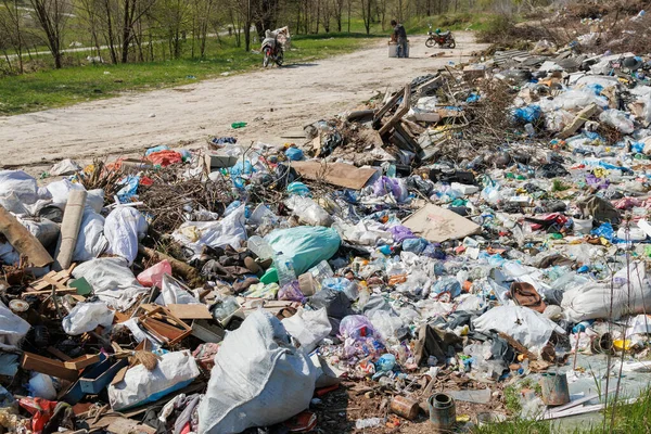 Çöp sahasının manzarası. Çöp yığını. Bir yığın plastik çöp, yiyecek atıkları ve diğer çöpler. Kirlilik konsepti. Bir çöp denizi, güzel bir kırsal alanı istila etmeye ve yok etmeye başlar..