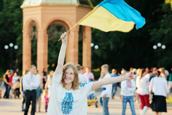 Romny, Sumy bölgesi, Ukrayna. Gençlik Günü, 29 Haziran 2014. Ulusal Ukrayna kostümü içinde nakışlı bir elbise giyen bir kız Ukrayna bayrağı taşıyor. Ukrayna 'daki savaşa karşı protesto.