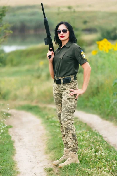 Soldier woman in military uniform. A girl in a military uniform with a weapon.