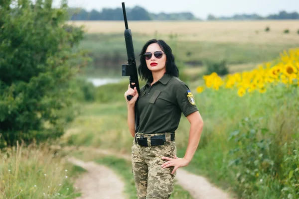 Soldier woman in military uniform. A girl in a military uniform with a weapon.